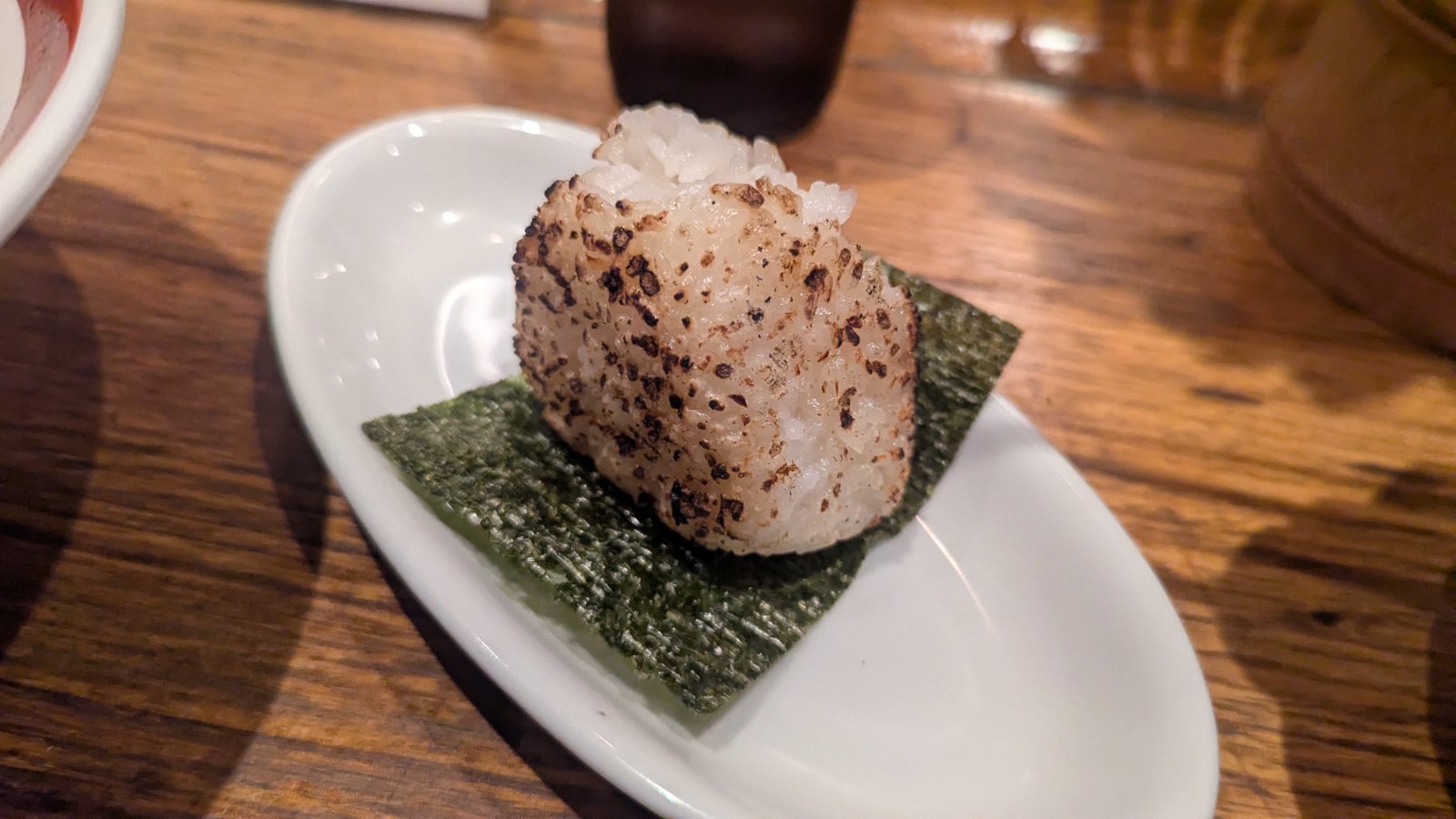 Grilled soy‑glazed onigiri served on nori