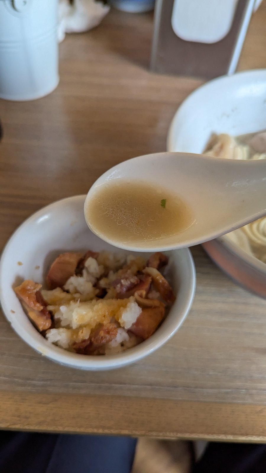 Ramen broth being poured over char siu rice bowl